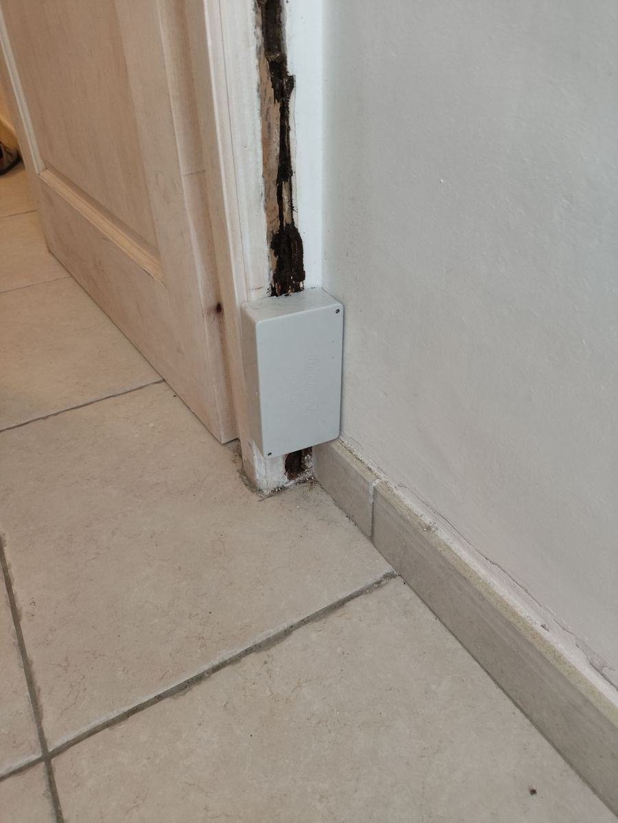 Station curative anti-termites refermée et vissée sur un montant de porte